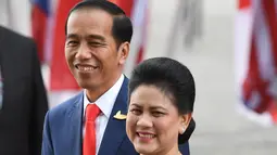 Presiden RI, Joko Widodo didamping Ibu Negara Iriana Widodo tersenyum saat tiba menghadiri KTT G20 di aula Elbphilharmonie di Hamburg, Jerman, (7/7). Sejumlah pemimpin negara berkumpul dalam KTT G20 pada 7-8 Juli 2017. (AFP Photo/Patrik Stollarz)