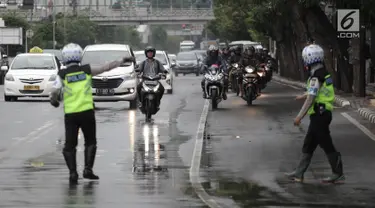 Polisi memberhentikan pengendara motor yang melanggar aturan pada jalur kiri khusus sepeda motor di Jalan MH Thamrin-Medan Merdeka Barat, Jakarta Pusat, Kamis (8/2). (Liputan6.com/Arya Manggala)