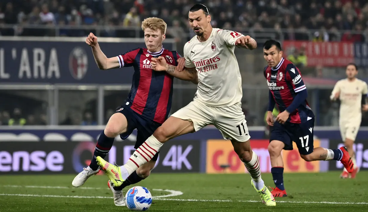 Penyerang AC Milan, Zlatan Ibrahimovic berebut bola dengan pemain Bologna, Jerdy Schouten pada pertandingan  Liga Serie A Italia di stadion Renato Dall'Ara, Italia, Minggu (24/10/2021). Kemenangan ini untuk sementara mengantarkan Milan ke puncak klasemen dengan 25 poin. (Massimo Paolone/LaPresse vi