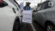 Pedagang menawarkan kalender tahun 2021 kepada pengguna jalan di perempatan Pondok Pinang, Kebayoran, Jakarta Selatan, Senin (7/12/2020). Jelang pergantian tahun, sejumlah pedangang mulai menjajakan kalender tahun 2021 dengan harga Rp 20 ribu-Rp 40 ribu tergantung ukuran. (merdeka.com/Dwi Narwoko)