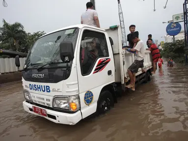 Petugas Dinas Perhubungan (Dishub) mengevakuasi karyawan dan warga yang terjebak banjir di Jalan Boulevard Raya, Kelapa Gading, Jakarta, Kamis (15/2). Banjir diakibatkan guyuran hujan sejak pagi hingga sore. (Liputan6.com/Arya Manggala)