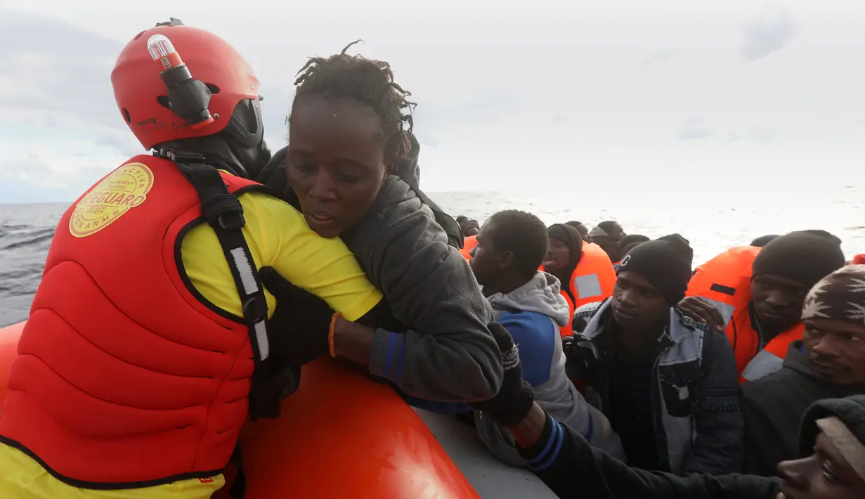 Penjaga pantai Spanyol menyelamatkan imigran asal Afrika di Laut Meditarania, sekitar 36 mil laut dari lepas pantai Libya (2/2). Penyelamatan yang dilakukan penjaga pantai Spanyol LSM Proactiva Open Arms ini sudah yang ke-112. (Reuters/Yannis Behrakis)
