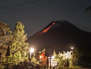 Lava pijar mengalir dari kawah Gunung Merapi di Yogyakarta, Sabtu (23/1/2021). Balai Penyelidikan dan Pengembangan Teknologi Kebencanaan Geologi (BPPTKG) menyebutkan Gunung Merapi mengeluarkan 17 kali guguran lava pijar dengan jarak luncur 300-500 meter pada Sabtu (23/1) pagi. (AFP/Agung Supriyanto)