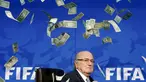 Presiden FIFA, Sepp Blatter terdiam saat uang kertas dilemparkan kepada dirinya saat tiba untuk konferensi pers usai Rapat Luar Biasa Komite Eksekutif FIFA di markas FIFA di Zurich, Swiss (20/7/2015). (REUTERS/Arnd Wiegmann)