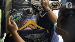 Penjahit memilih bahan yang akan dijahit di Nyoel Jeans co, Jakarta, Jumat (22/10/2021). Kapas adalah salah satu bahan baku utama pembuatan kain dalam industri tekstil di Indonesia. (Liputan6.com/Faizal Fanani)