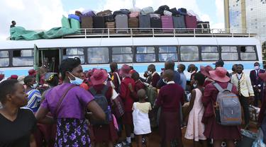 Anak-anak sekolah menunggu untuk naik bus menuju sekolah di Harare, Minggu (6/2/2022). Sekolah-sekolah di Zimbabwe dibuka kembali pada 7 Februari setelah penundaan selama berminggu-minggu dalam mengizinkan siswa kembali menyusul meningkatnya infeksi COVID-19. (AP Photo/Tsvangirayi Mukwazhi)