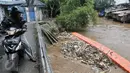 Warga melihat tumpukan sampah yang tertahan di dekat pintu air Manggarai, Jakarta, Rabu (8/3). Hujan deras yang mengguyur kawasan Jabodetabek semalam membuat aliran air Ciliwung meningkat dan membawa sampah. (Liputan6.com/Yoppy Renato)