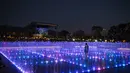 Seorang pria berdiri di dalam pertunjukan cahaya dan air Natal yang ditampilkan di Experience Park, di distrik pesisir Hellenikon di Athena, Yunani, Senin (20/12/2021).  (AFP/Angelos Tzortzinis)