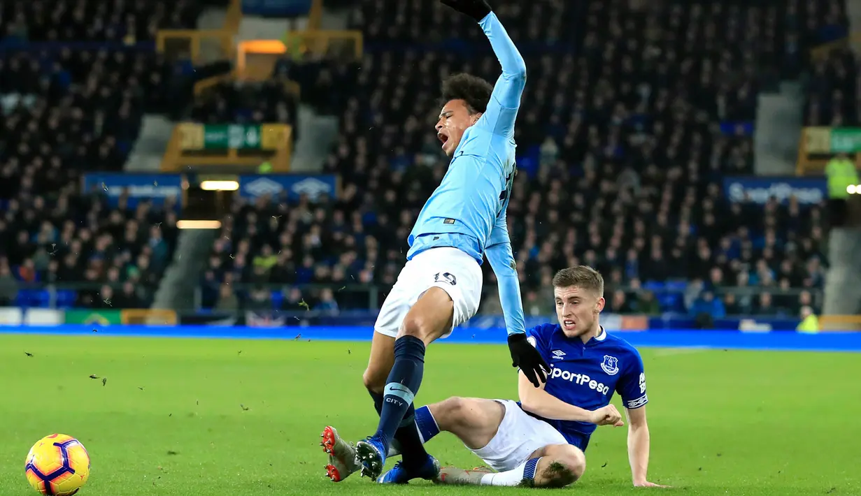 Gelandang Manchester City, Leroy Sane saat dilanggar pemain Everton, Jonjoe Kenny selama pertandingan lanjutan Liga Inggris di Goodison Park Stadium (6/2). City memiliki poin 62 sama seperti Liverpool.  (Peter Byrne/PA via AP)