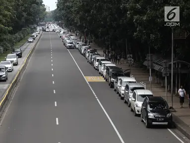 Ratusan mobil sopir taksi online terparkir di Jalan Medan Merdeka Barat, Jakarta, Rabu (14/2). Mereka menolak Permenhub Nomor 108 Tentang Penyelenggaraan Angkutan Orang Dengan Kendaraan Bermotor Umum Tidak Dalam Trayek. (Liputan6.com/Arya Manggala)