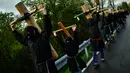 Sejumlah peninten mengenakan topeng membawa salib saat ritual musim semi '' Romeria Cruceros de Arce '' di Spanyol utara (13/5). Mereka berjalan memikul salib dari kota kecil Pyrenees menuju Gereja Roncesvalles. (AP / Alvaro Barrientos)
