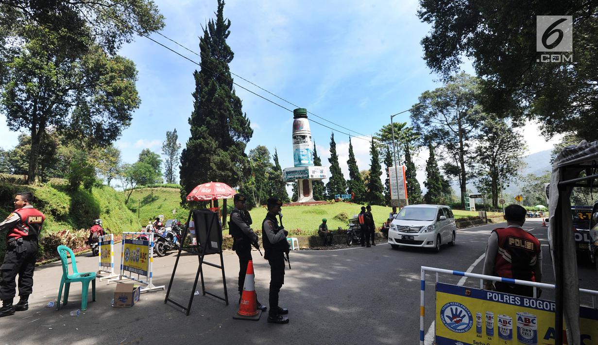 Petugas polisi berjaga di kawasan Puncak, Bogor (29/03). Akibat penutupuan itu pedagang mengeluh karena daerah mereka berjualan jadi sepi pembeli.  (Merdeka.com/Arie Basuki)