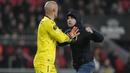 <p>Seorang suporter fanatik PSV berusaha menyerang kiper Sevilla, Marko Dmitrovic dalam laga leg kedua babak playoff fase gugur Liga Europa 2022/2023 di Philips Stadium, Eindhoven, Jumat (24/2/2023). (AP Photo/Peter Dejong)</p>