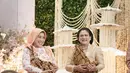 Iriana Jokowi pilih kebaya brukat gold, sedangkan Sofiatun Gudono pilih kebaya print flora. Dipadukan dengan hijab polos berwarna peach