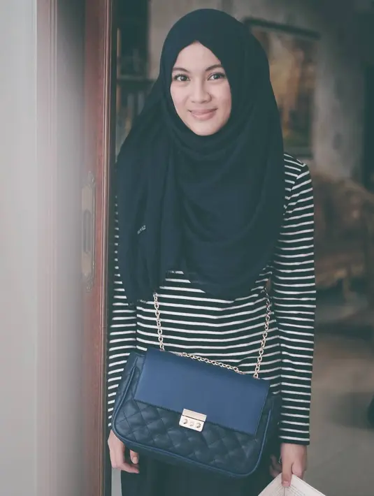 Gaya monokrom Icha kali ini keren banget. Baju bermotif garis-garis hitam putihnya dipadukan dengan hijab hitam polosnya. Ia juga mengenakan celana hitam dan juga sling bag yang warnanya hitam juga. (Instagram/ichasoebandono)