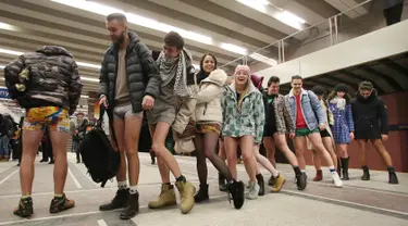 Penumpang mengantre naik kereta tanpa mengenakan celana selama berpartisipasi dalam 'No Pants Subway Ride' di Polandia (8/1). Acara tahunan ini digelar di berbagai negara khususnya naik kereta tanpa memakai celana. (AP Photo/Czarek Sokolowski)