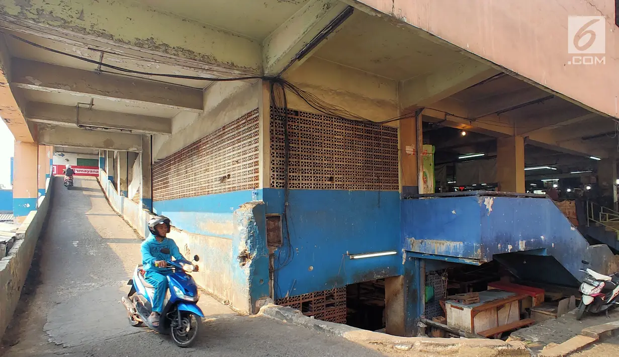 Pengendara motor melintas di pasar tradisional Pasar Mingu di Jakarta, Rabu (17/7). Rencana revitalisasi 21 pasar tradisional di Ibu Kota terancam molor karena status lahan pasar masih dalam proses perubahan sertifikasi. (Liputan6.com/Immanuel Antonius)