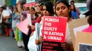 Sejumlah wanita India menunjukkan poster saat aksi protes kasus perkosaan di Ahmadabad, India (16/4). Protes ini dipicu karena perkosaan dan pembunuhan yang menimpa seorang gadis berusia 8 tahun. (AP Photo / Ajit Solanki)