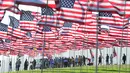Orang-orang membantu pengibaran bendera AS untuk peringatan 20 tahun serangan 9/11 di Pepperdine University di Malibu, California, Rabu (8/9/2021). Selama 14 tahun, universitas itu memperingati tragedi 11 September 2001 dengan mengibarkan sekitar 3.000 bendera Amerika. (Frederic J. BROWN/AFP)
