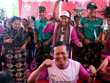 Menteri BUMN Rini Soemarno (tengah belakang) bersama Direktur ASABRI Sonny Widjaja (tengah depan) joget bersama masyarakat usai peresmian bantuan bedah rumah di Desa Oebelo, Kupang, Nusa Tenggara Timur (NTT), Selasa (14/8). (Liputan6.com/JohanTallo)