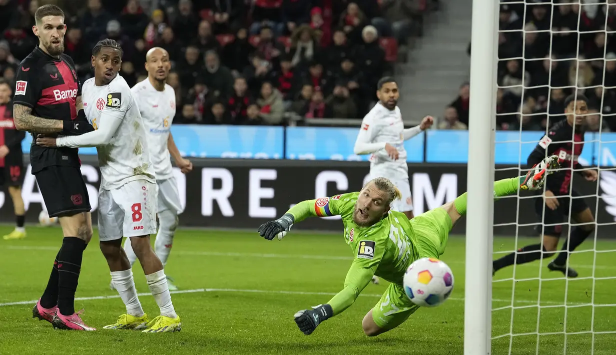 Kiper Mainz, Robin Zentner, gagal menghalau bola saat melawan Bayer Leverkusen dalam duel pekan ke-23 Bundesliga di Stadion BayArena, Sabtu (24/2/2024). (AP Photo/Martin Meissner)