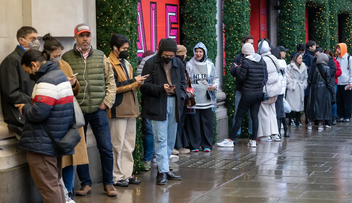 <p>Antrean pembeli, yang beberapa mengenakan masker, untuk memasuki department store Selfridges menjelang penjualan Boxing Day di pusat kota London, Minggu (26/12/2021). 'Boxing Day' adalah hari saat toko-toko di Inggris menggelar diskon besar-besaran, sehari setelah Natal. (Niklas HALLE'N / AFP)</p>