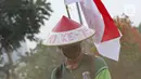 Petugas Pertamanan dan Kehutanan Kota Jakarta Pusat mengenakan atribut kemerdekaan saat memotong rumput di TPU Karet Bivak, Jakarta, Minggu (16/8/2020). Para petugas bekerja dengan mengenakan atribut kemerdekaan dalam rangka menyambut HUT ke-75 RI. (Liputan6.com/Herman Zakharia)