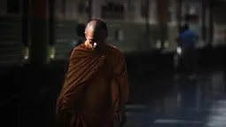 Seorang biksu Buddha berjalan di sepanjang platform kereta api di stasiun kereta api Hua Lampong, sehari sebelum Songkran Festival, atau Tahun Baru Thailand, di Bangkok (12/4). (AFP Photo/Lillian Suwanrumpha)