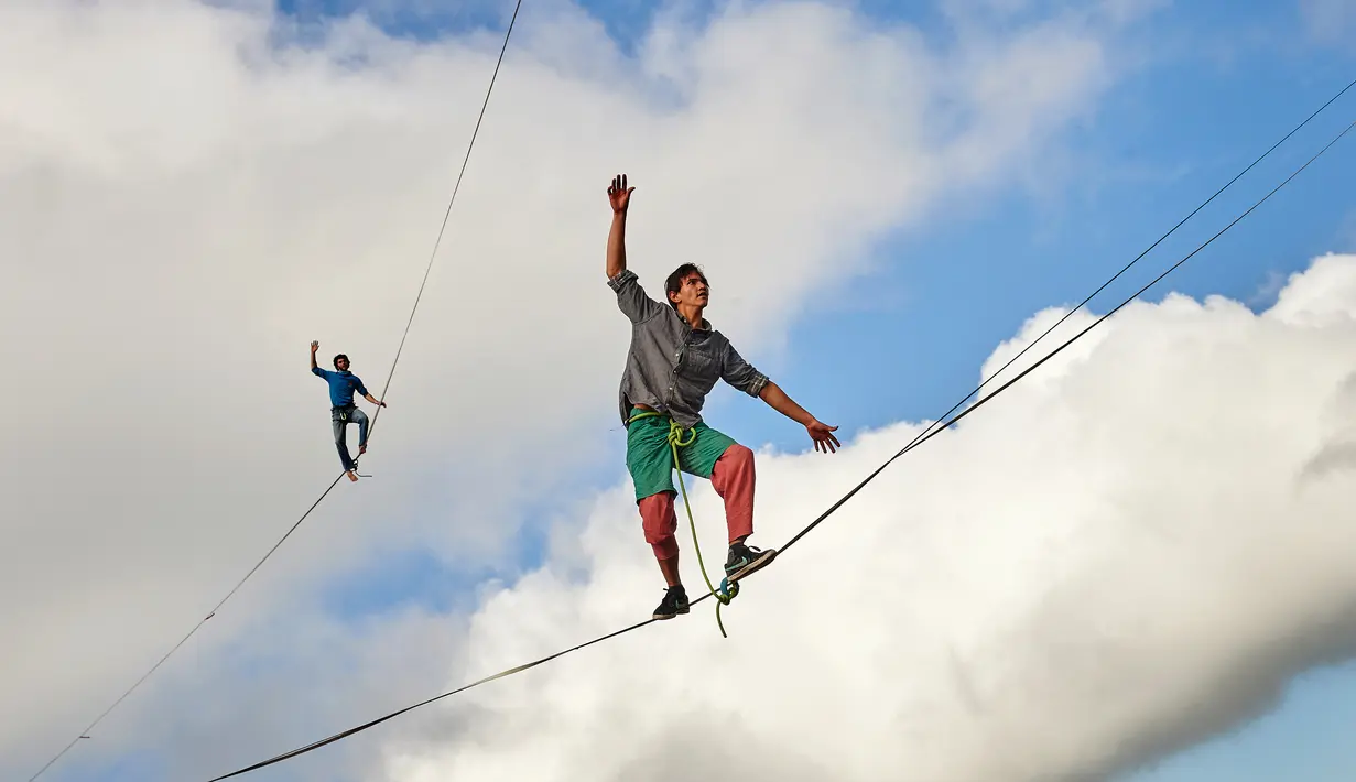 Sebastian Gum Chung Segraves (kanan) dan Daniel Laruelle dari Afrika Selatan berjalan diatas tali saat acara Highline Extreme di puncak Moleson, Swiss (15/9).Berjalan di seutas tali diatas ketinggian ini disebut slackline. (AFP Photo/Michael Buholzer)