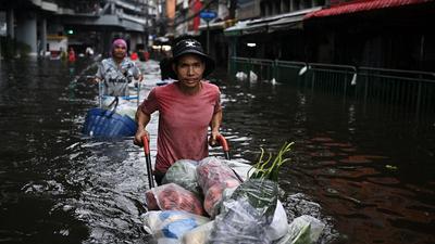 Banjir Parah Rendam Bangkok Warga Berjualan di Tengah Genangan
