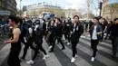 Sejumlah massa berjalan memadati Place de la Republique saat menggelar aksi, Paris, Prancis (2/4). Aksi mereka ini dipicu oleh kematian pria bernama Shaoyo Liu, 56, yang diduga tewas di tangan polisi. (AFP/Benjamin Cremel)
