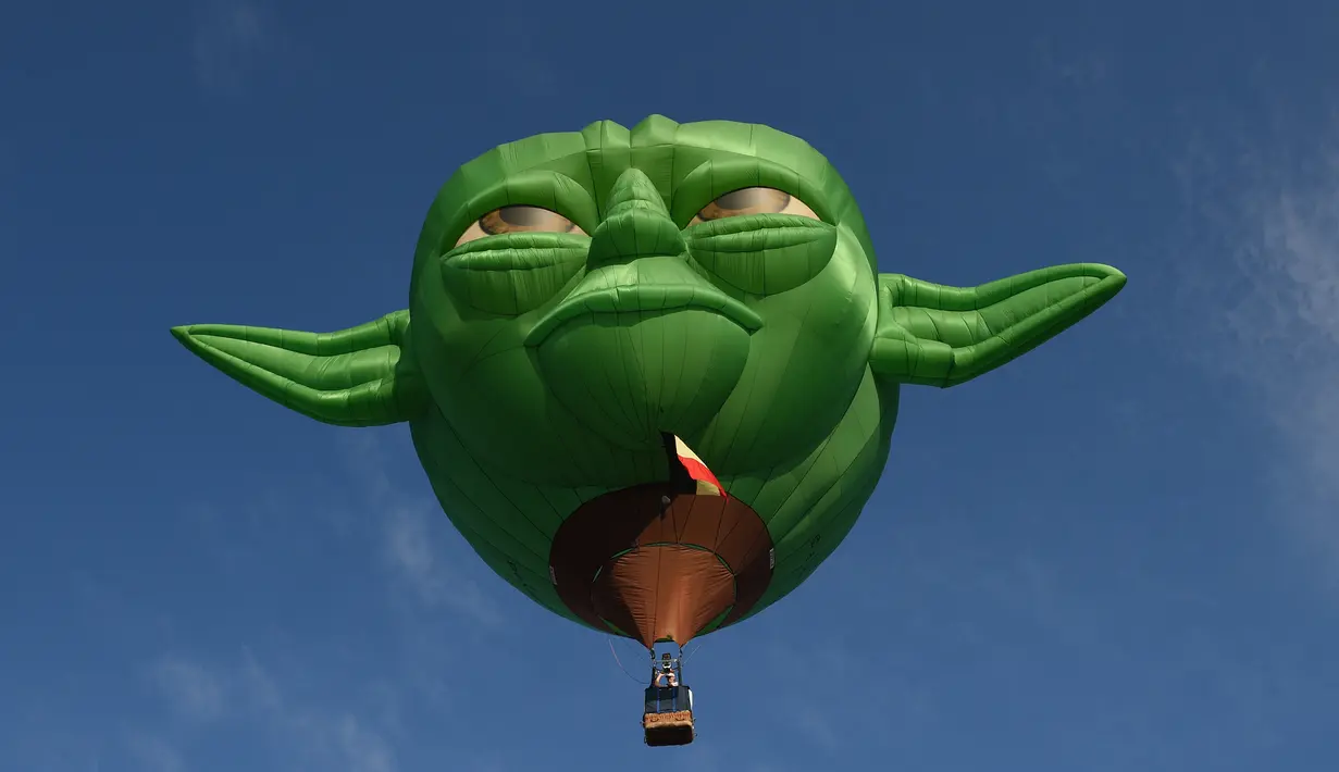 Balon udara raksasa berbentuk karakter film Star Wars Yoda terbang dalam Festival Balon Udara Internasional di Clark, Utara Manila, Provinsi Pampanga, Filipina, Jumat (9/2). Acara berlangsung pada 9-12 Februari. (TED ALJIBE/AFP)
