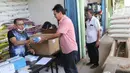 Wakil Ketua Umum Persatuan Pengusaha Penggilingan Padi dan Beras (Perpadi) Billy Haryanto memberikan obat ke buruh di Pasar induk beras Cipinang, Jakarta, Sabtu (16/5/2020). (Liputan6.com/Herman Zakharia)