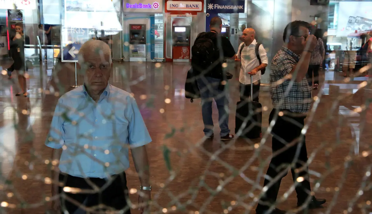 Seorang pria mengamati kaca jendela yang retak di Bandara Ataturk, Istanbul, Turki, Rabu (29/6). Aktivitas di bandara internasional tersebut berangsur normal pasca ledakan bom bunuh diri yang menewaskan 42 korban jiwa. (REUTERS/Goran Tomasevic)