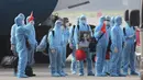 Pasien COVID-19 asal Vietnam mengenakan alat pelindung diri saat tiba di Bandara Noi Bai, Hanoi, Vietnam, Rabu (29/7/2020). Sebanyak 129 pekerja asal Vietnam dipulangkan dari Equatorial Guinea untuk mendapat perawatan COVID-19. (Tran Huy Hung/VNA via AP)
