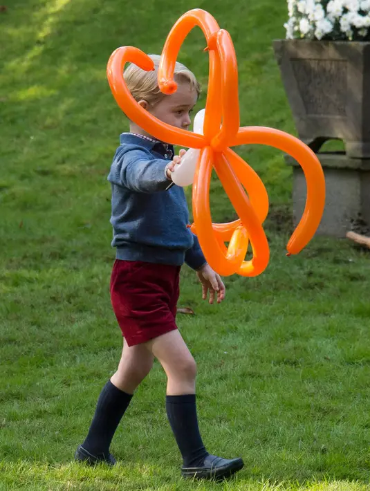 Pangeran George berjalan membawa balon saat menghadiri pesta anak-anak di Government House di Victoria, British Columbia, Kanada, (29/9). (REUTERS/Chris Wattie)
