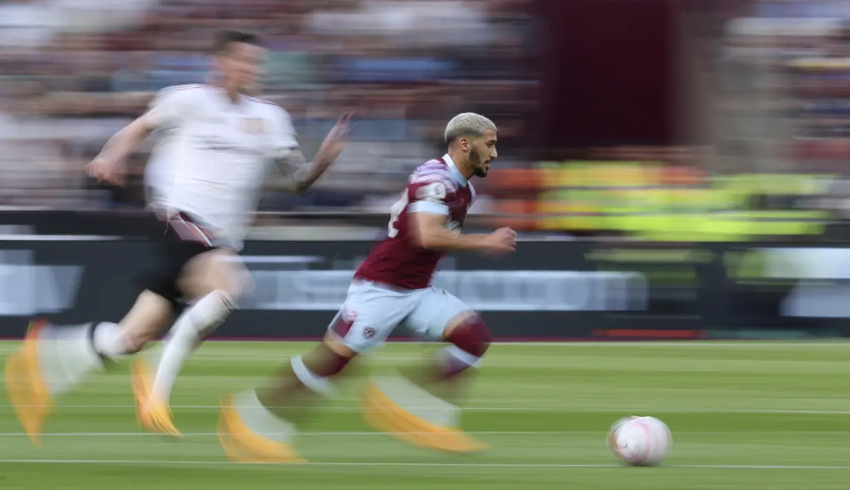 Pemain West Ham United, Said Benrahma (kanan), mengontrol bola dibayangi pemain MU dalam laga pekan ke-35 Premier League 2022/2023 yang berlangsung di London Stadium, Senin (8/5/2023) dini hari. (AP Photo/Ian Walton)