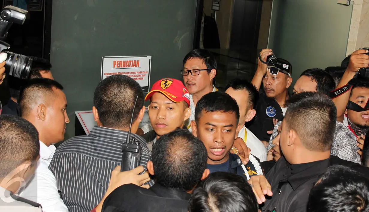 Rekan pengacara dari OCK and Associate mencoba menghalangi peliputan para wartawan yang hendak mengambil gambar salah seorang pengacara terduga pemberi suap, di Gedung KPK, Jakarta, (Liputan6.com/Helmi Afandi)
