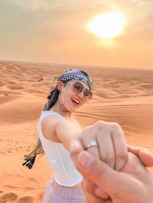 Foto terbaru menampilkan Via Vallen pamer cincin kawin. Jemari penyanyi bernama asli Maulidia Octavia digenggam sang suami, yang hanya kelihatan tangannya dalam foto. Memakai penutup kepala serban monokrom dan kacamata, Via Vallen tersenyum lebar ke arah kamera. “Gak gosong, gak pulang,” celotehnya di medsos pada 9 Agustus 2022. (Foto: Dok. Instagram @viavallen)