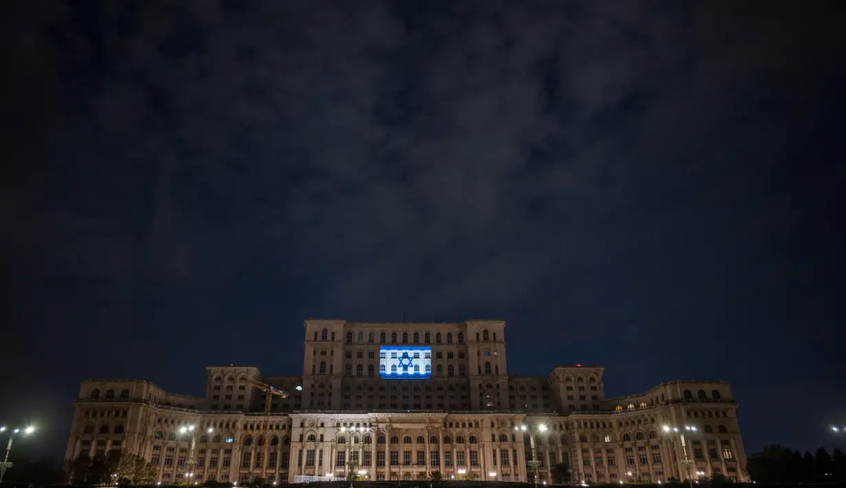 Bendera Israel menerangi Istana Parlemen sebagai bentuk solidaritas terhadap Israel di Bucharest, Rumania, Senin (9/10/2023). (AP Photo/Vadim Ghirda)
