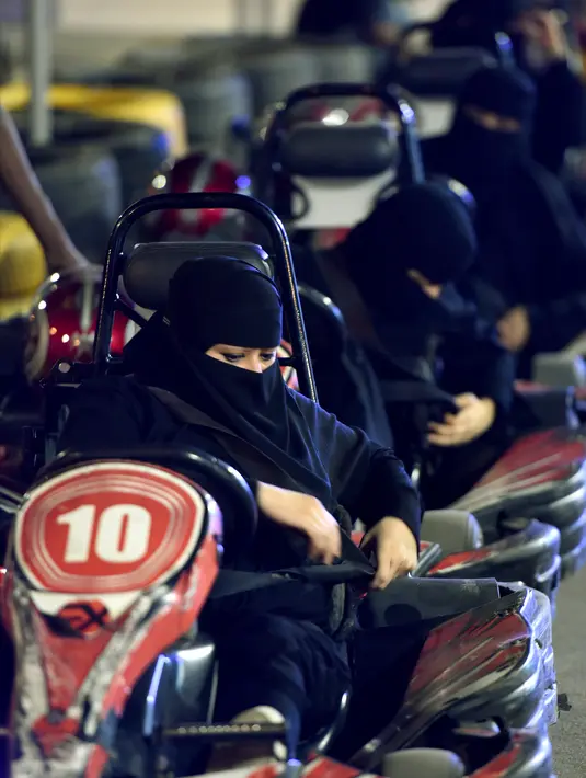 Para wanita menggunakan sabuk pengaman sebelum mencoba gokart selama workshop di Ibu Kota Riyadh, Arab Saudi, Kamis (21/6). Pemerintah Arab Saudi kini telah memperbolehkan kaum wanita untuk mengendarai kendaraan. (FAYEZ NURELDINE/AFP)