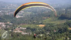 Olahraga Paralayang menjadi pilihan warga yang berkunjung ke Puncak Pass, Bogor, Jumat (6/4). Olahraga yang memacu adrenalin ini dipatok dengan harga Rp. 350 Ribu. (Liputan6.com/Johan Tallo)