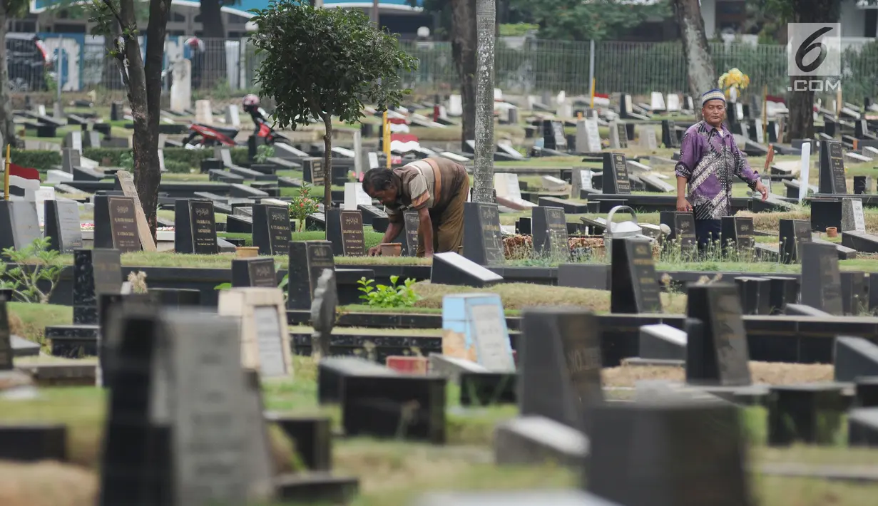 Petugas membersihkan makam di TPU Tanah Kusir, Jakarta, Selasa (29/8). Sudin Kehutanan DKI Jakarta berencana memperluas area TPU Tanah Kusir. Perluasan dilakukan karena kebutuhan lahan pemakaman sangat tinggi. (Liputan6.com/Helmi Fithriansyah)