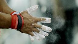 Atlet angkat besi, Deni, memakai Bubuk Magnesium karbonat saat latihan di Pelatnas angkat besi, Jakarta, Rabu (21/3/2018). Latihan tersebut untuk persiapan Asian Games 2018. (Bola.com/M Iqbal Ichsan)