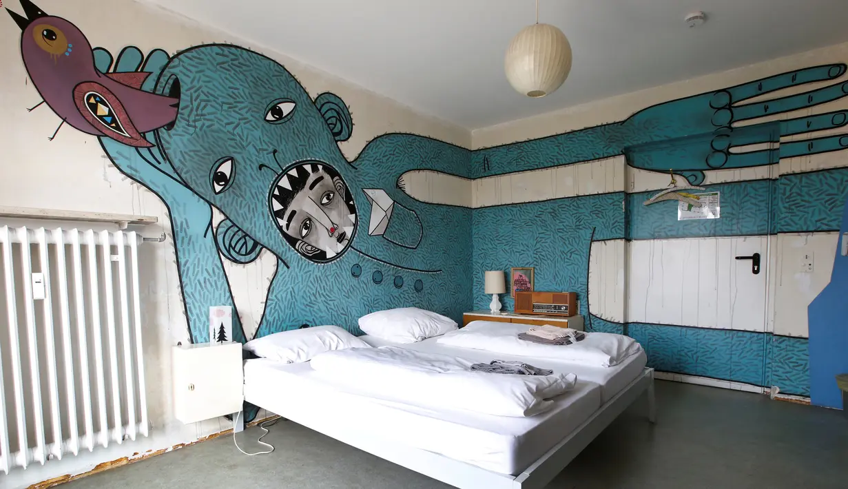 Suasana kamar tidur untuk tamu dengan latar belakang lukisan orang di hotel "Grandhotel Cosmopolis", yang dipersiapkan untuk para imigran dan wisatawan dari seluruh dunia, di Augsburg, Jerman, 27 Juli 2016. (REUTERS/Michaela Rehle)
