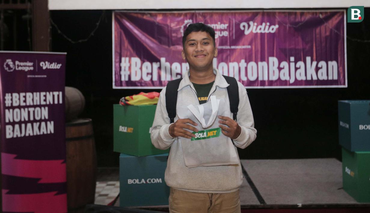 Seorang peserta kuis yang beruntung mendapatkan merchandise dari sponsor dalam acara Roaring Night Liga Inggris 2023/2024 antara Manchester United (MU) melawan Everton di Bunker Terrace Cafe di Java Palace Hotel Jababeka, Cikarang, Sabtu (9/3/2024) malam WIB. (Bola.com/Pradipta Rama Baskara)