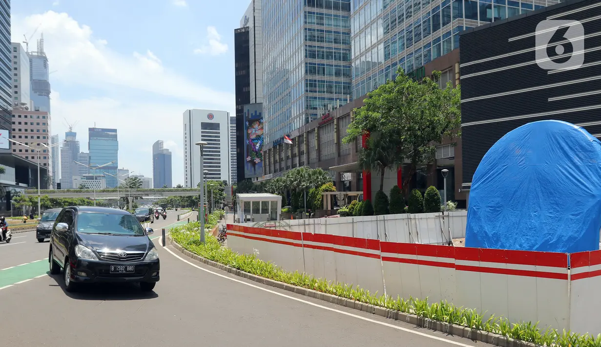 Kendaraan melintas dekat proyek pembangunan Tugu Sepeda di  kawasan Jenderal Sudirman, Jakarta, Rabu (22/9/2021). Dinas Perhubungan DKI Jakarta memastikan pembangunan Tugu Sepeda masih berlanjut, dan pembangunnya hingga saat ini telah mencapai 90 persen. (Liputan6.com/Herman Zakharia)