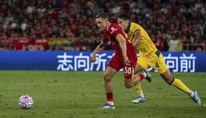 Penggawa Liverpool Florian Wirtz (kiri) melewati bek AC Milan Samuele Ricci pada laga di Kai Tak Stadium, Sabtu (26/7/2025) malam WIB. (AP Photo/Chan Long Hei)