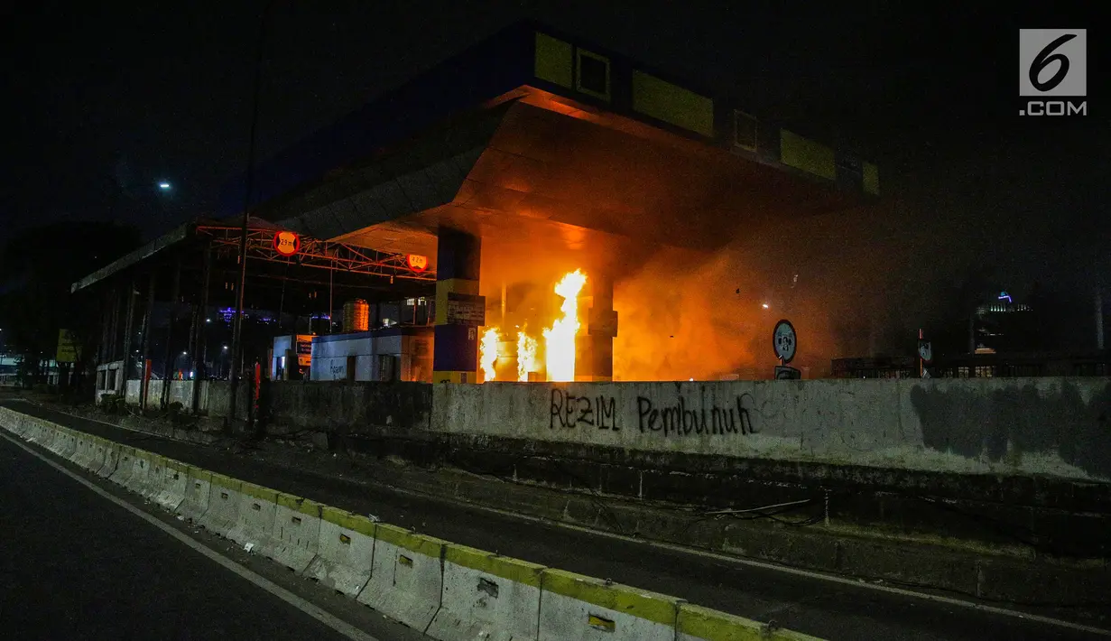 Gardu Tol Pejompongan 1 dibakar massa saat demonstrasi mahasiswa di depan Gedung DPR/MPR, Jakarta, Selasa (24/9/2019). Demonstrasi mahasiswa berujung ricuh, polisi menembakkan gas air mata dan water cannon untuk membubarkan demo. (Liputan6.com/Faisal Fanani)