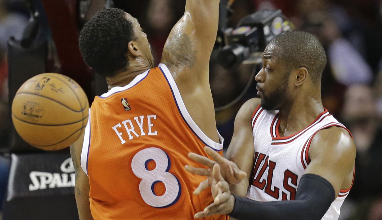 Pemain Chicago Bulls, Dwyane Wade (kanan) memberikan umpan kepada rekannya saat dihadang pemain Cleveland Cavaliers, Channing Frye pada aga NBA basketball game di Quicken Loans Arena, Cleveland. (AP/Tony Dejak)